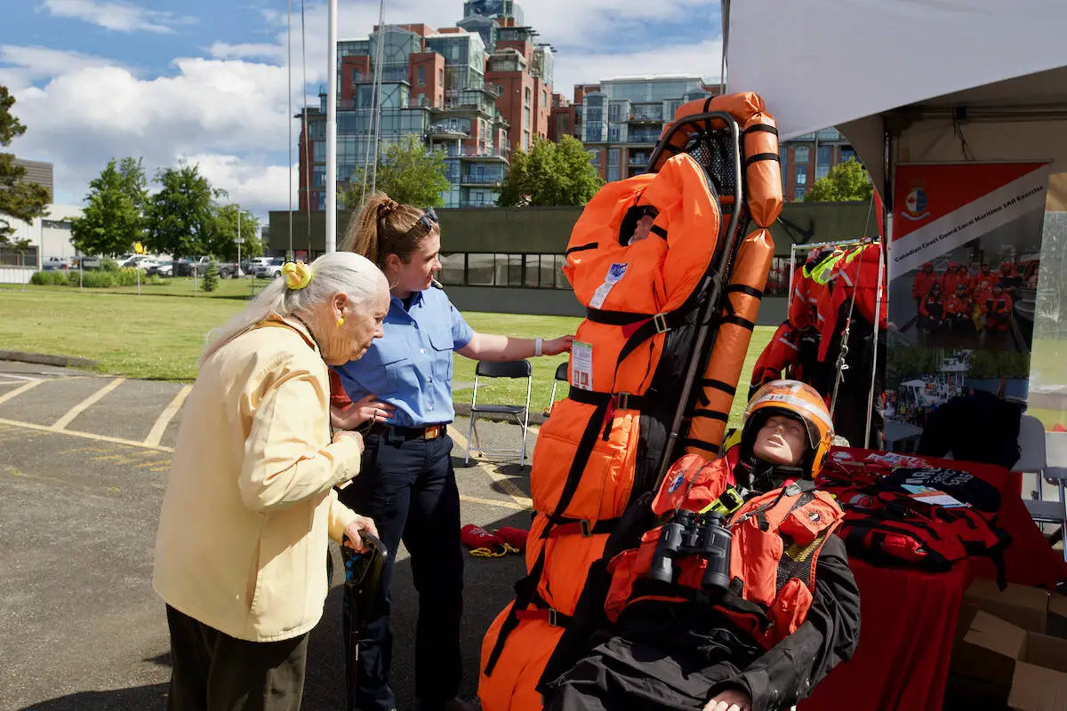 A coast guard member shows off rescue gear to a visitor during the inaugural Coast Guard Day June 11, 2022. (Justin Samanski-Langille/News Staff)